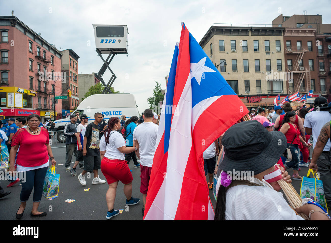 Thousands of visitors under the eye of an NYPD watchtower enjoy the