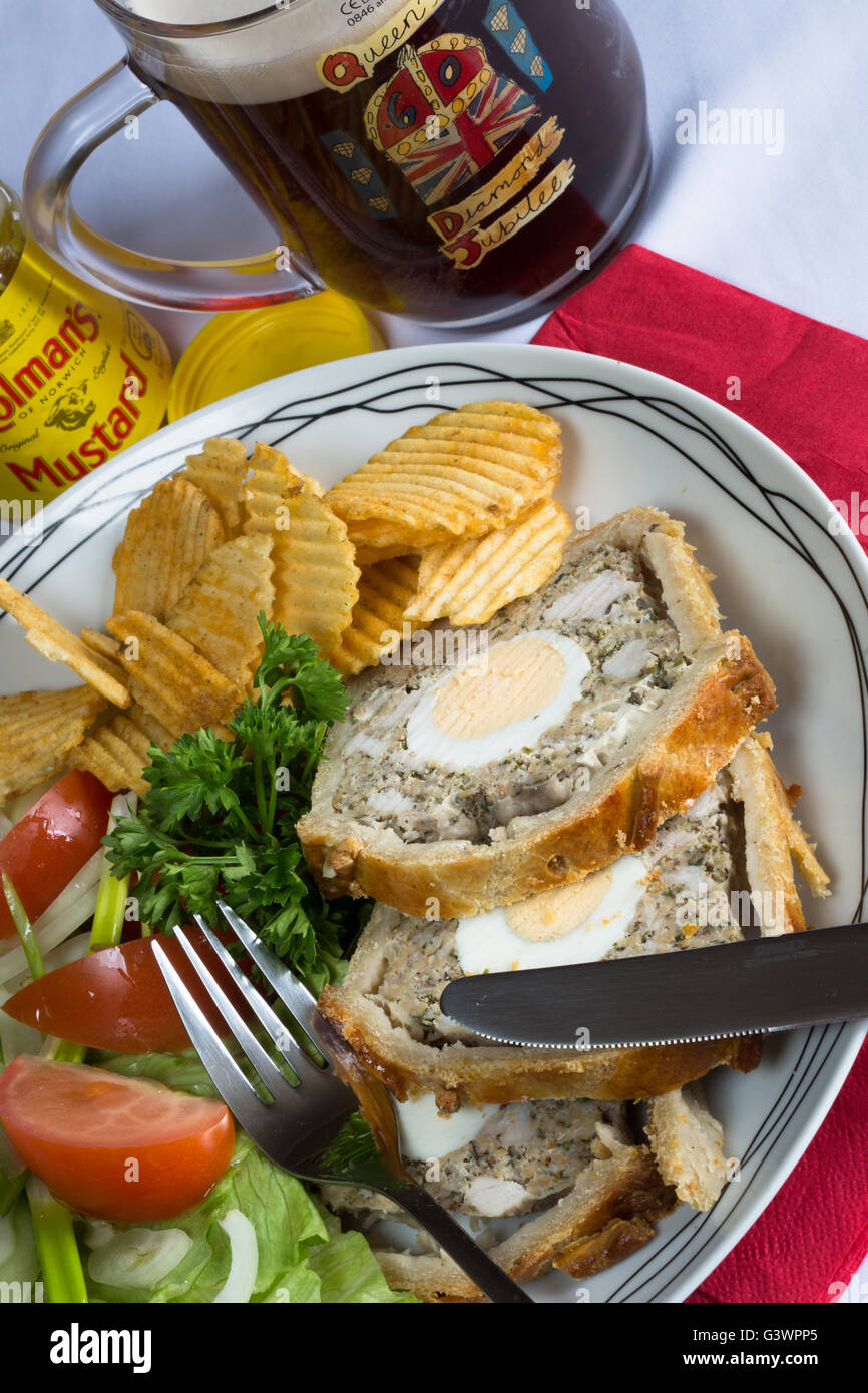 A plated lunch of homemade Gala Pie, Mixed Salad, served with a pint of English ale/beer Stock