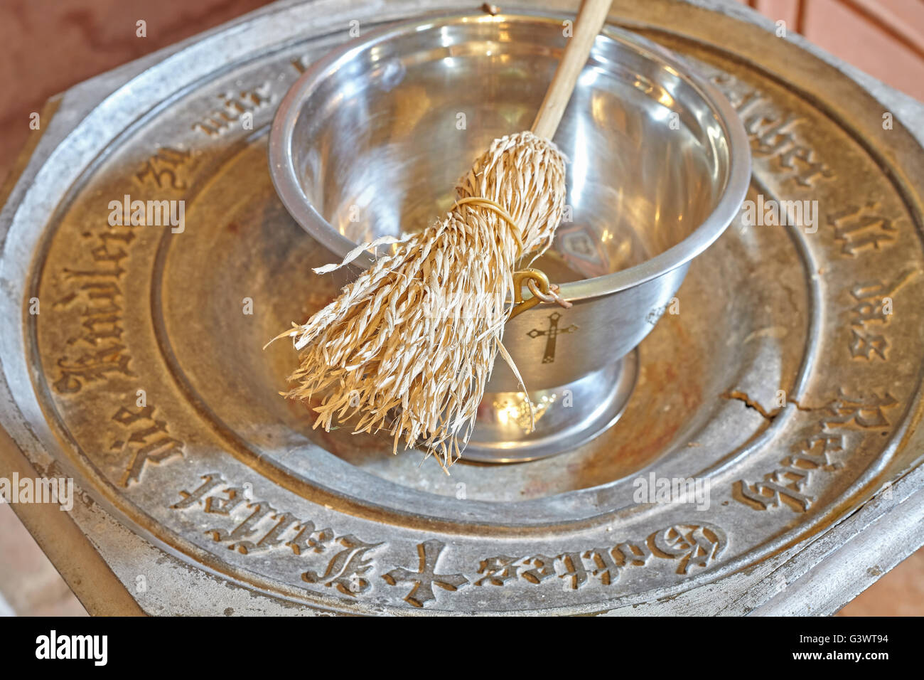 Baptismal font with sprinkler, shallow depth of field. Stock Photo