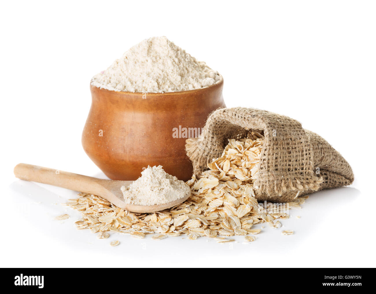 oat  wholegrain flour in bowl and  spoon,   bag with oat flakes isolated on a white background closeup Stock Photo