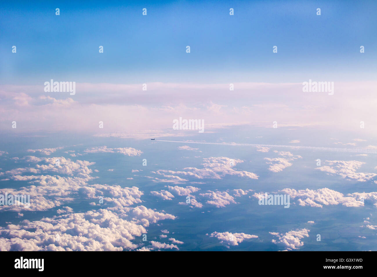 Aircraft flying away high above the clouds Stock Photo - Alamy