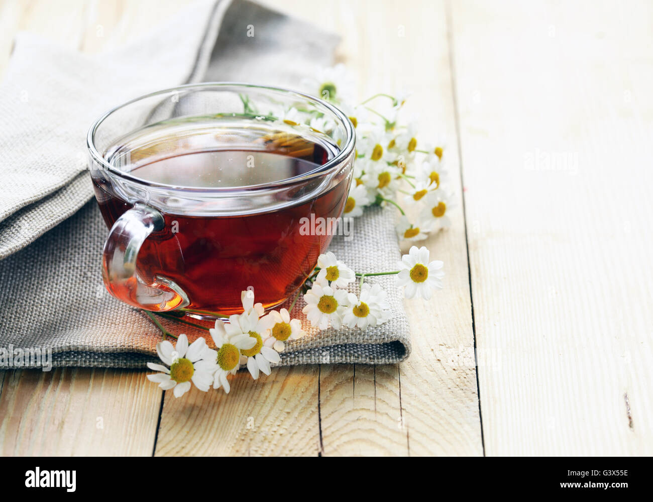 glass cup with tea and chamomile on a wooden background Stock Photo - Alamy