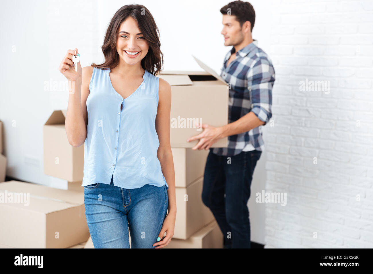 Happy married couple with key and boxes moving to new home Stock Photo ...