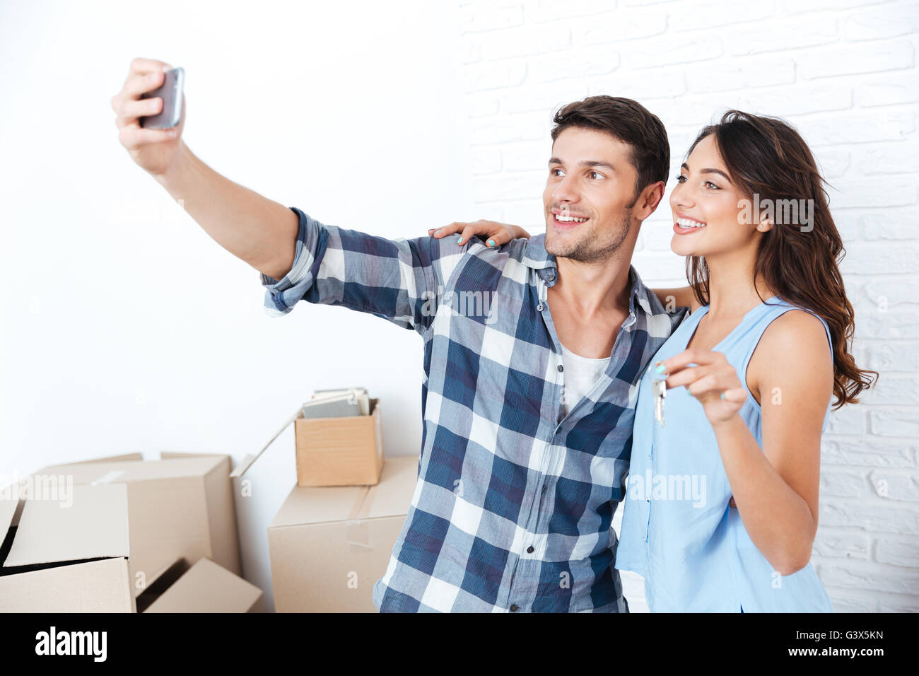 Young married happy couple making selfie holding keys in new flat Stock ...