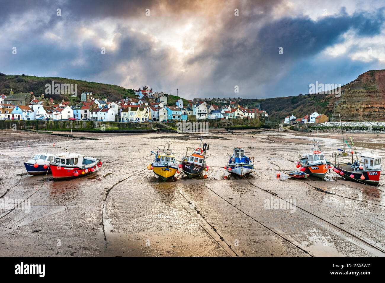 Fishing boats in Staithes harbour at low tide Stock Photo - Alamy