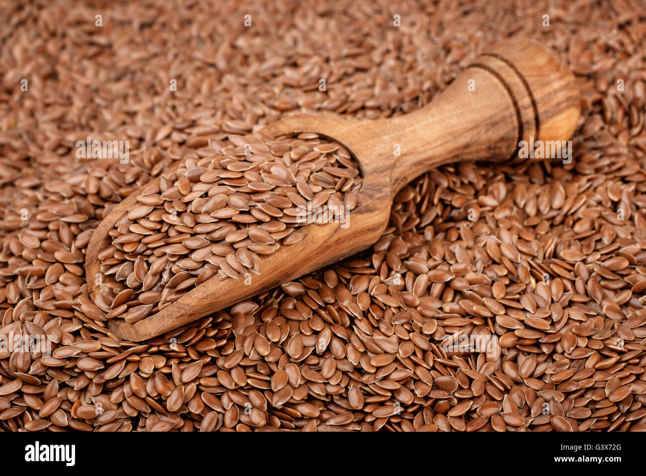 Wooden scoop with lin seeds Stock Photo