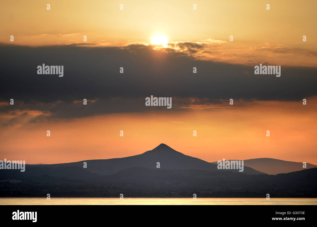 Evening sun over Wicklow Mountains national Park, Leinster, Ireland with Great Sugar Loaf hill, taken from the Irish sea Stock Photo