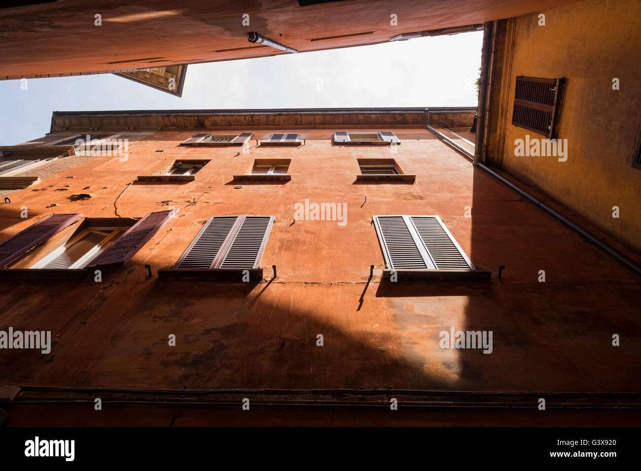 Looking up between apartment buildings in a typical narrow laneway in