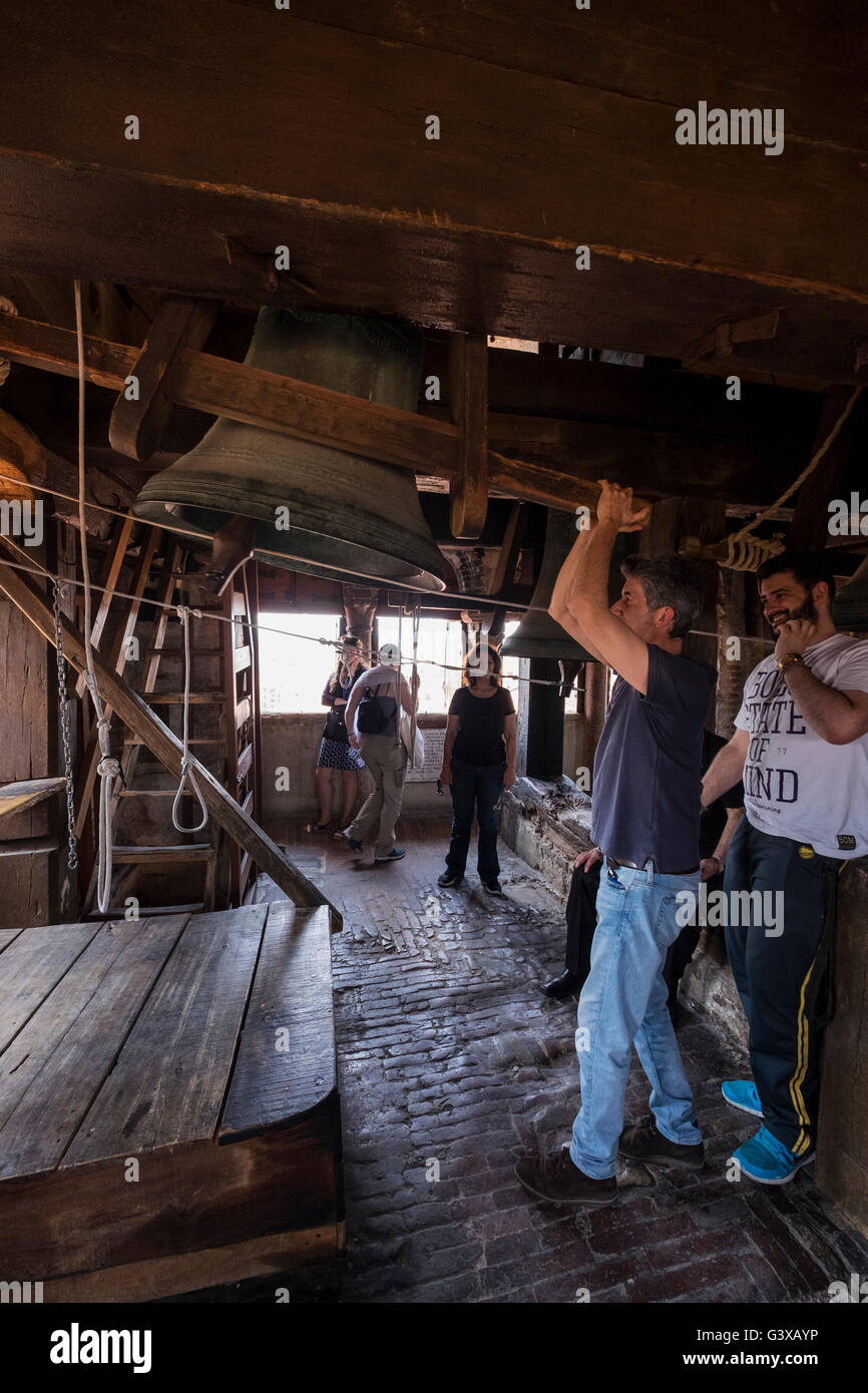 Visitor ringing a bell in the bell tower of the Cattedrale di San Pietro in Bologna, Italy. Stock Photo