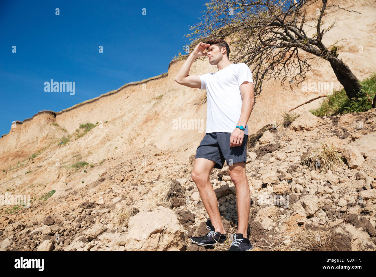 Handsome young man standing outdoors and looking far away Stock Photo ...