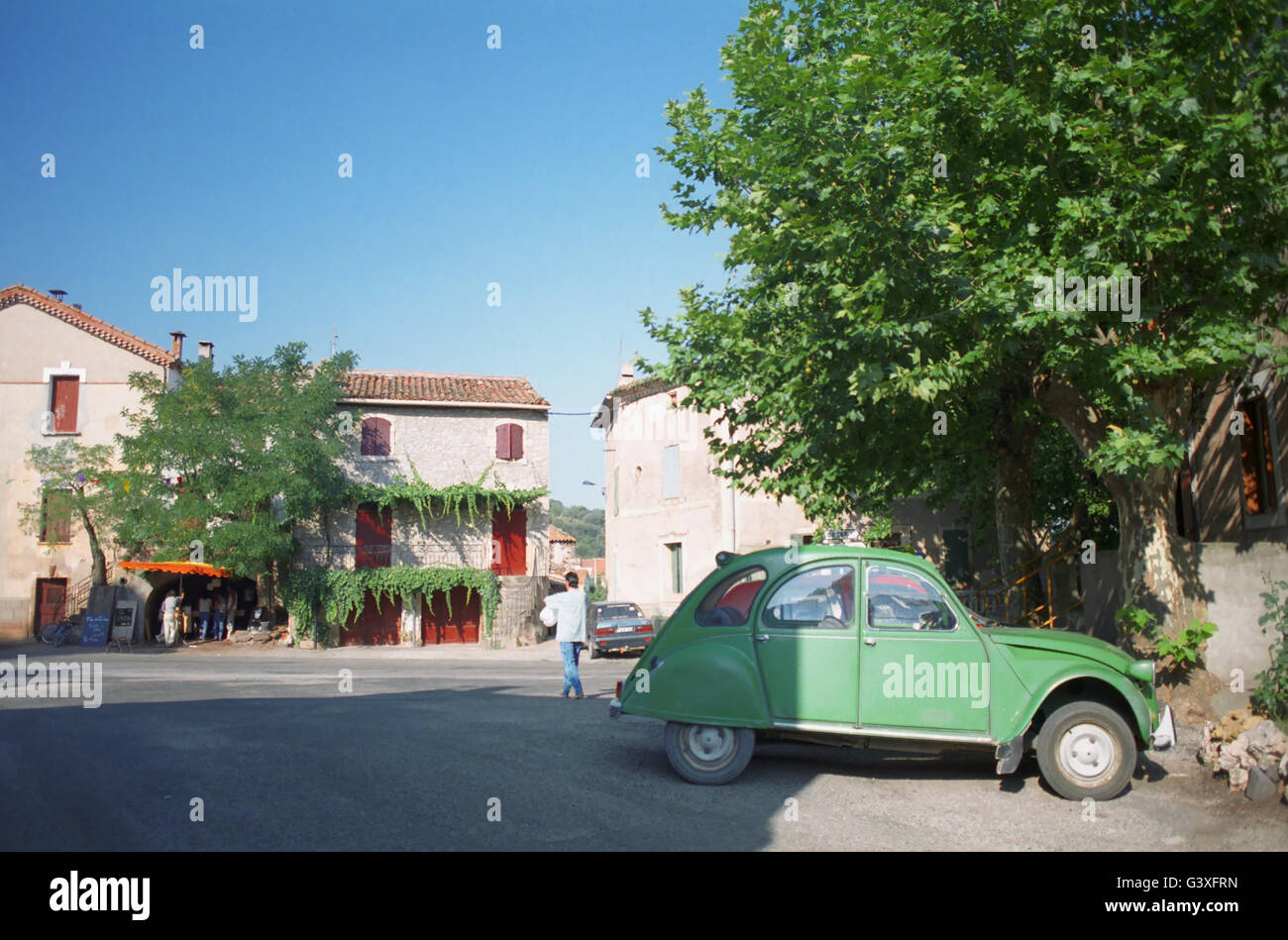 Green Citroën 2CV parked in village square: Rue de la Vialle, Octon, Hérault, Occitanie, France Stock Photo