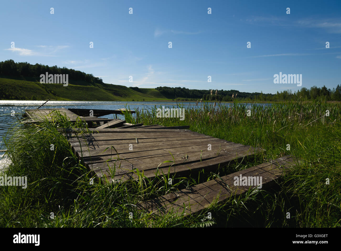 old wooden jetty at spring lake on a blue sky background Stock Photo