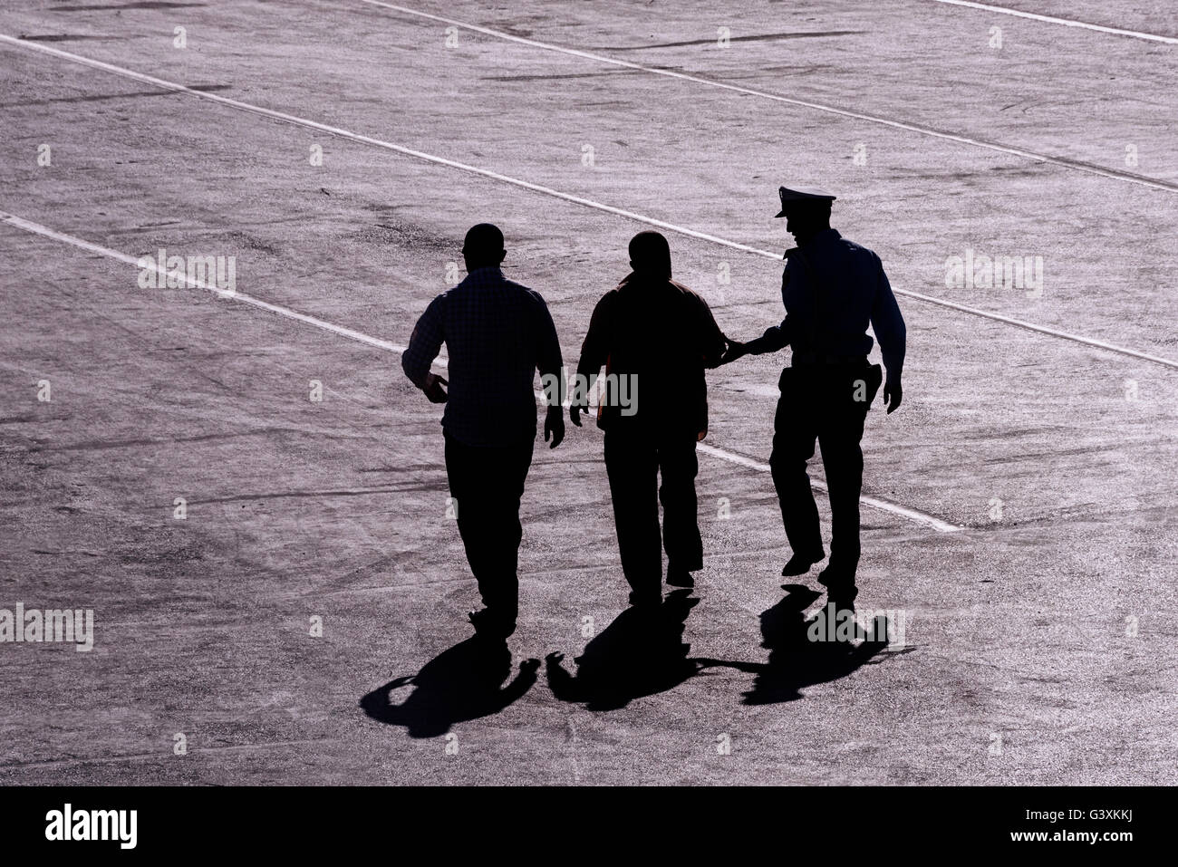 Aerial view of a backlight and arrest a citizen, led and guarded by local police at the port of Tanger (Morocco) Stock Photo