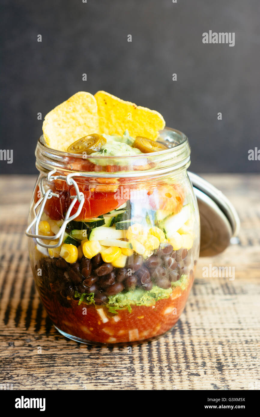 Mexican Salad in a Jar with salsa, lettuce, black beans, corn, zucchini, tomatoes, guacamole