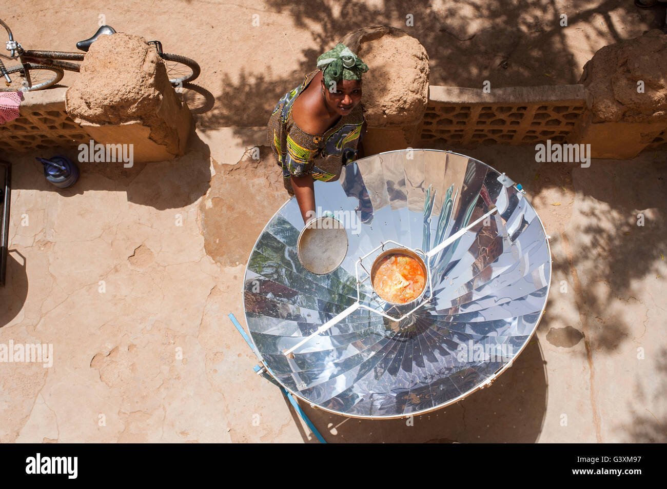 MALI Bandiagara, energy transition, woman with solar cooker, a parabolic mirror, preparing food in village Stock Photo