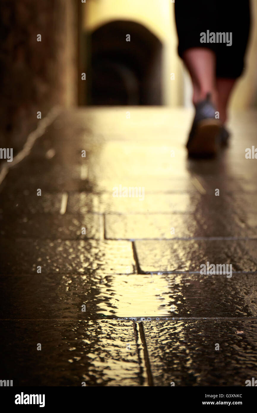 Walking away in the rain on rustic stone floor in italy Stock Photo