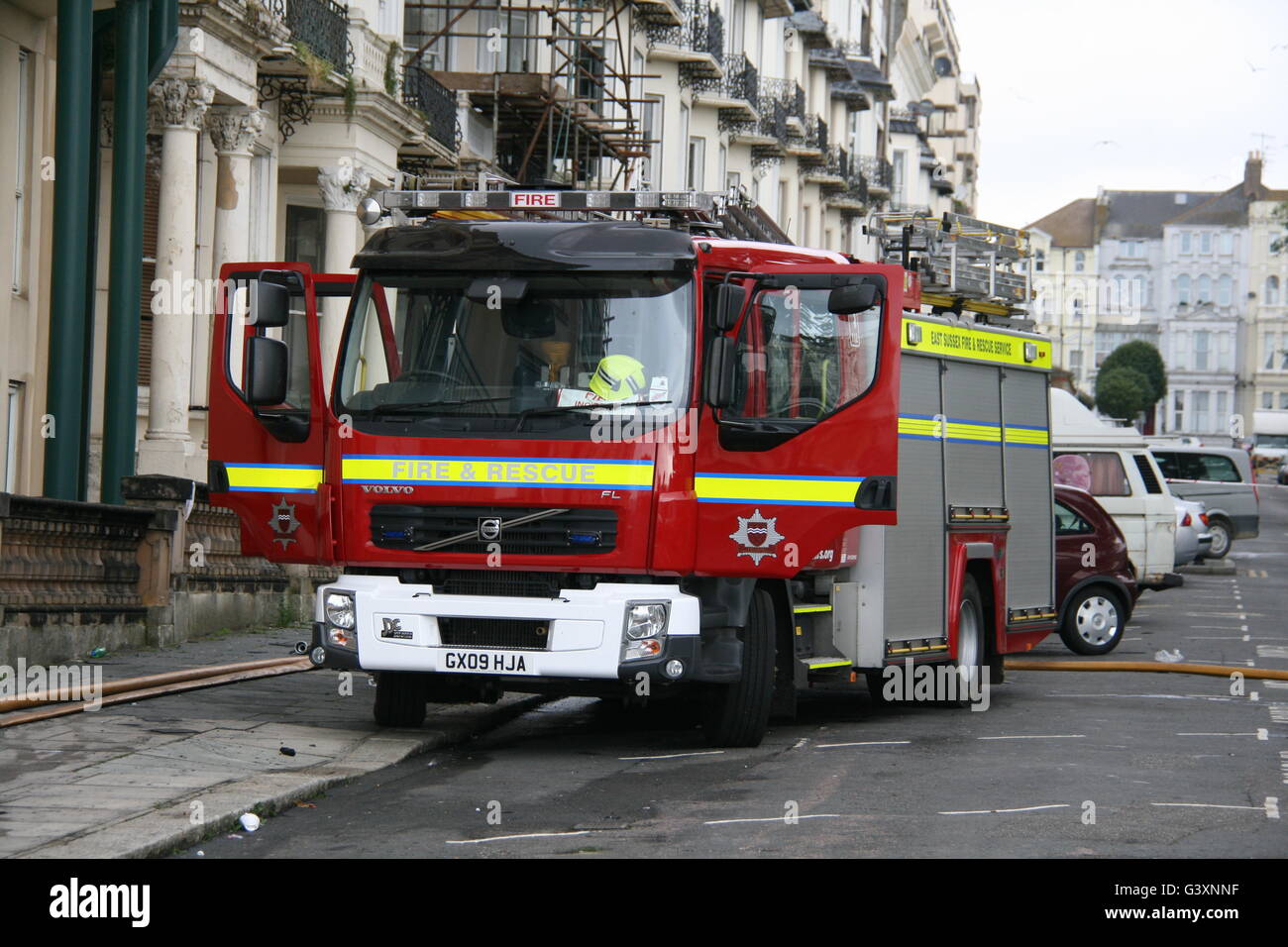 AN EAST SUSSEX FIRE & RESCUE VOLVO PUMP ATTENDING AN EMERGENCY INCIDENT WITH HOSES ON THE GROUND AROUND THE VEHICLE Stock Photo