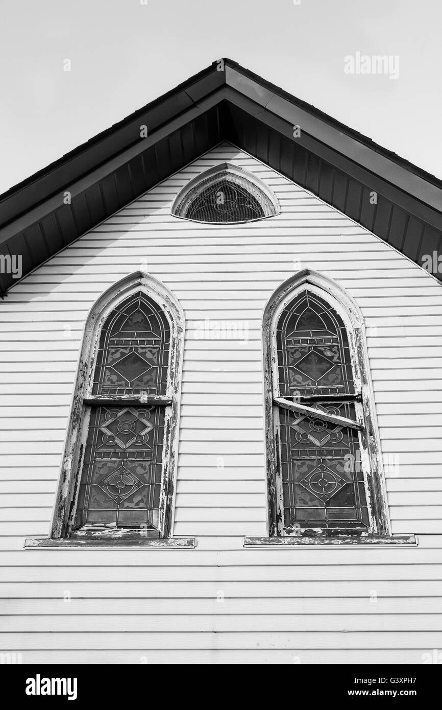 Old wooden church with simple, elegant pointed arch windows, in need of repair. Stock Photo