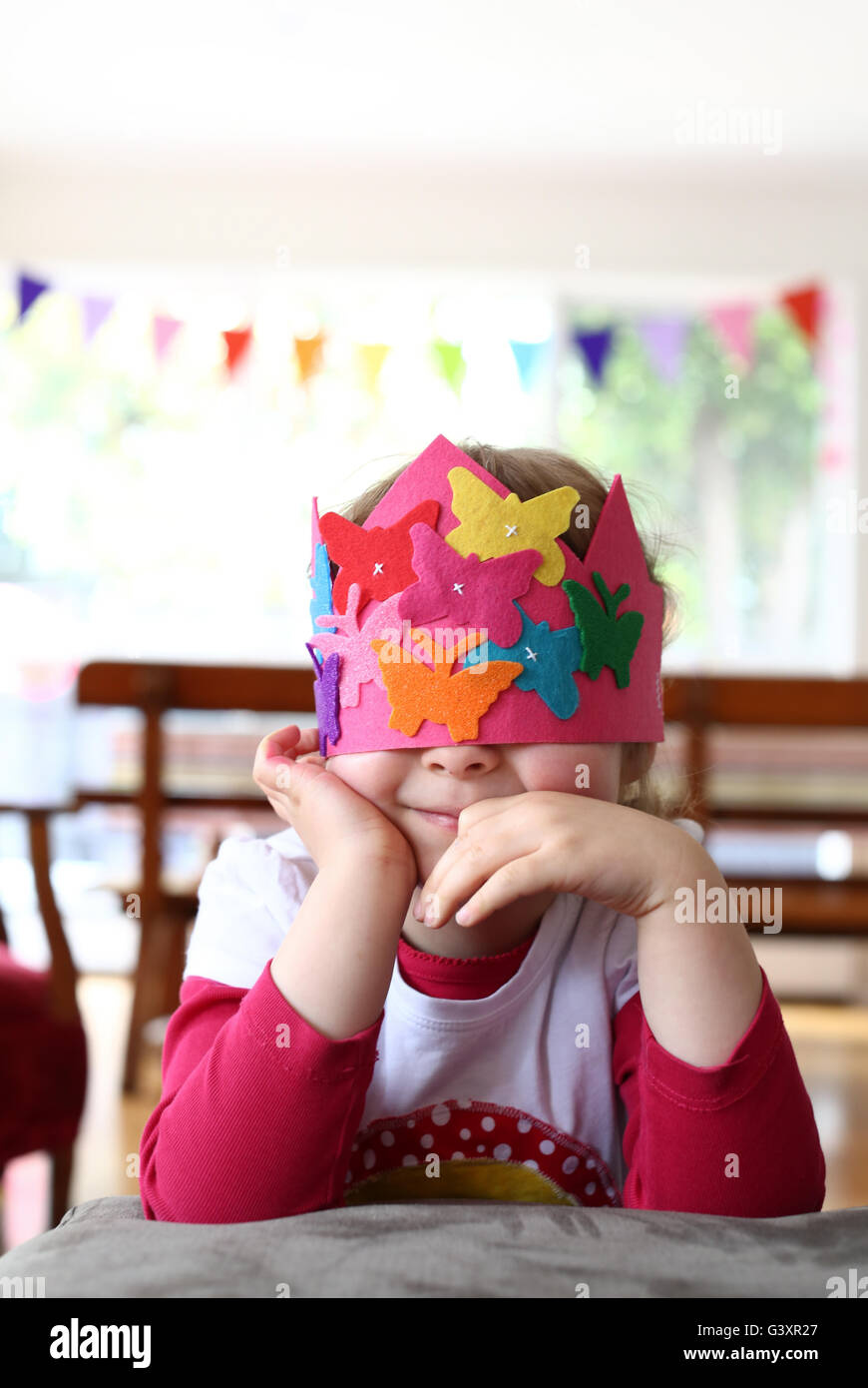 Young girl in a party hat covering her eyes Stock Photo Alamy