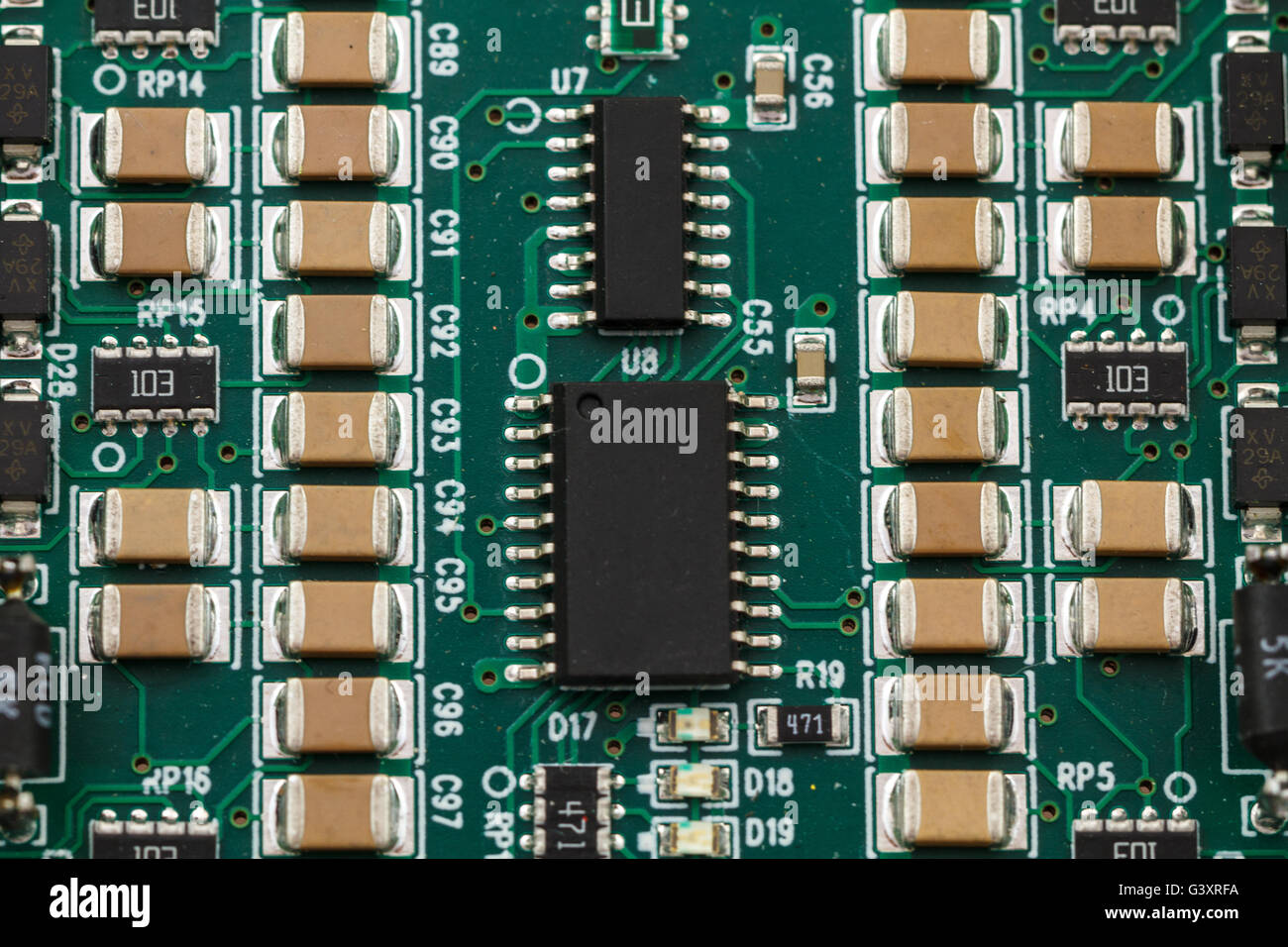 Printed circuit board with ICs, chip capacitors, and chip resistors. Stock Photo