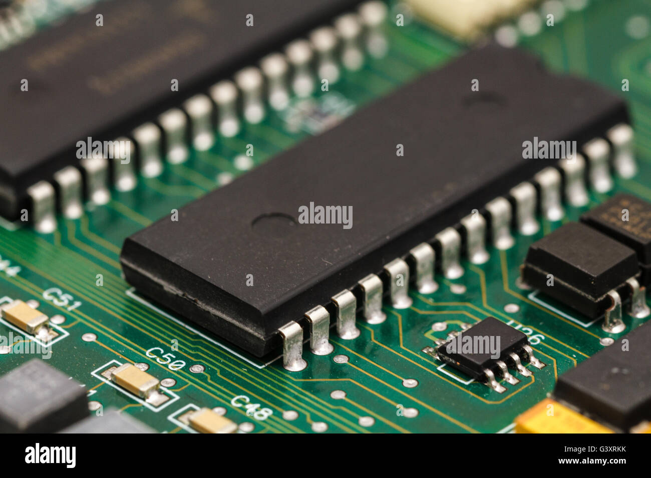Printed circuit board with ICs, chip capacitors, and chip resistors. Stock Photo