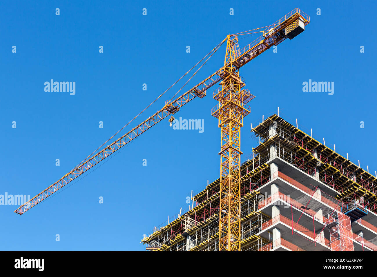Building construction site against blue sky with tower crane Stock Photo