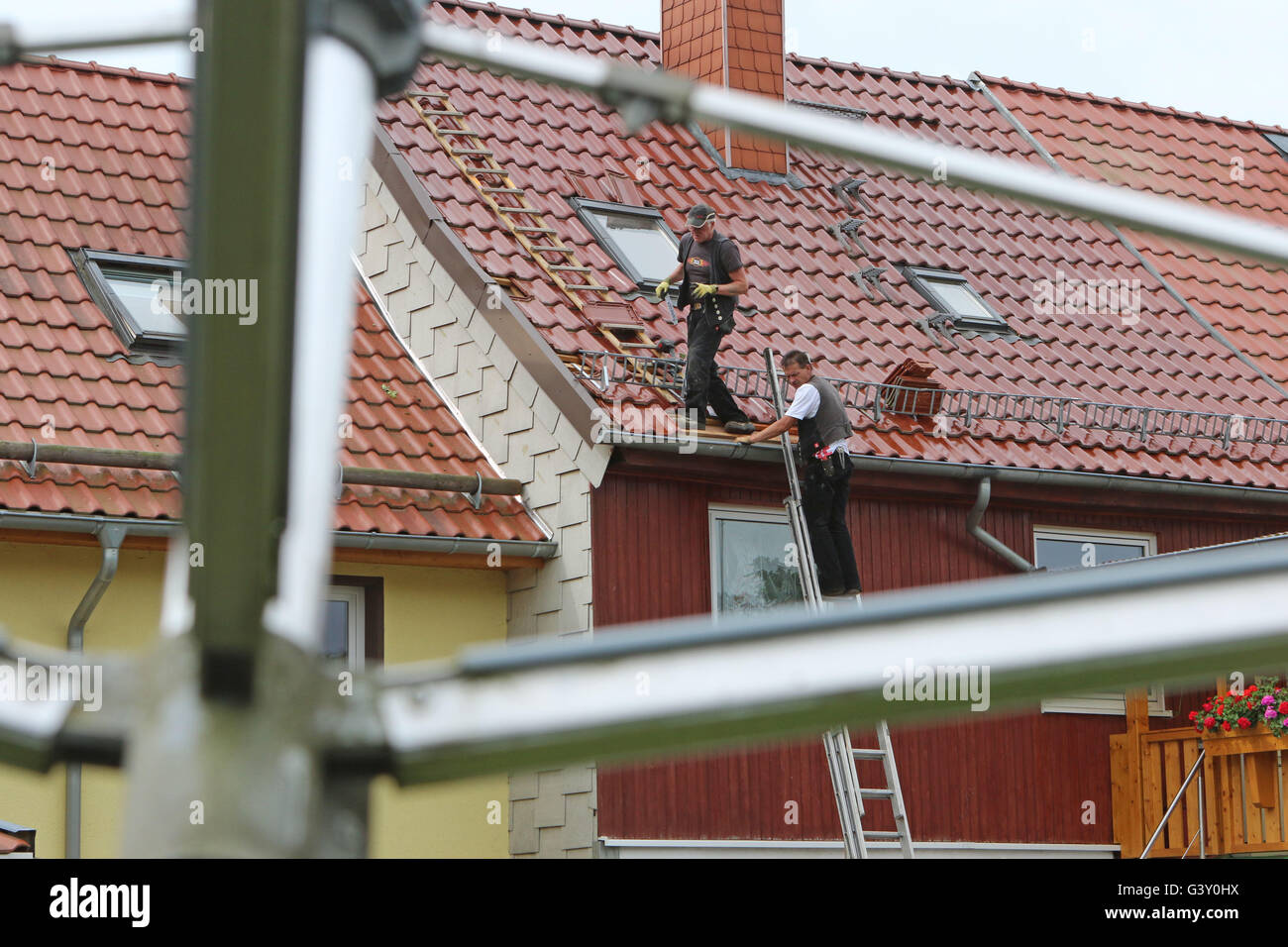 Ellrich, Germany. 16th June, 2016. Residents repair the sotrm damage in the centre of the village of Ellrich, germany, 16 June 2016. A tornado has caused substantial material damage in the Thuringian town. According to the police, the tornado has untiled the roofs of around 50 houses. There were no iunjuries. The clearing work is still ongoing. Photo: Matthias Bein/dpa/th Credit:  dpa picture alliance/Alamy Live News Stock Photo