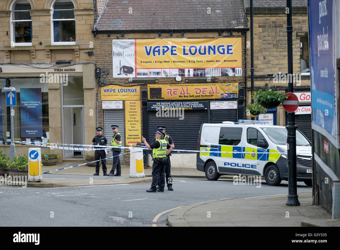 Market Street, Birstall near Leeds, West Yorkshire, UK. 16th June, 2016. Officers man a cordon at the junction of Chapel Lane and Market Street, a short distance from the scene of the shooting. Credit: Ian Wray Alamy Live News Stock Photo