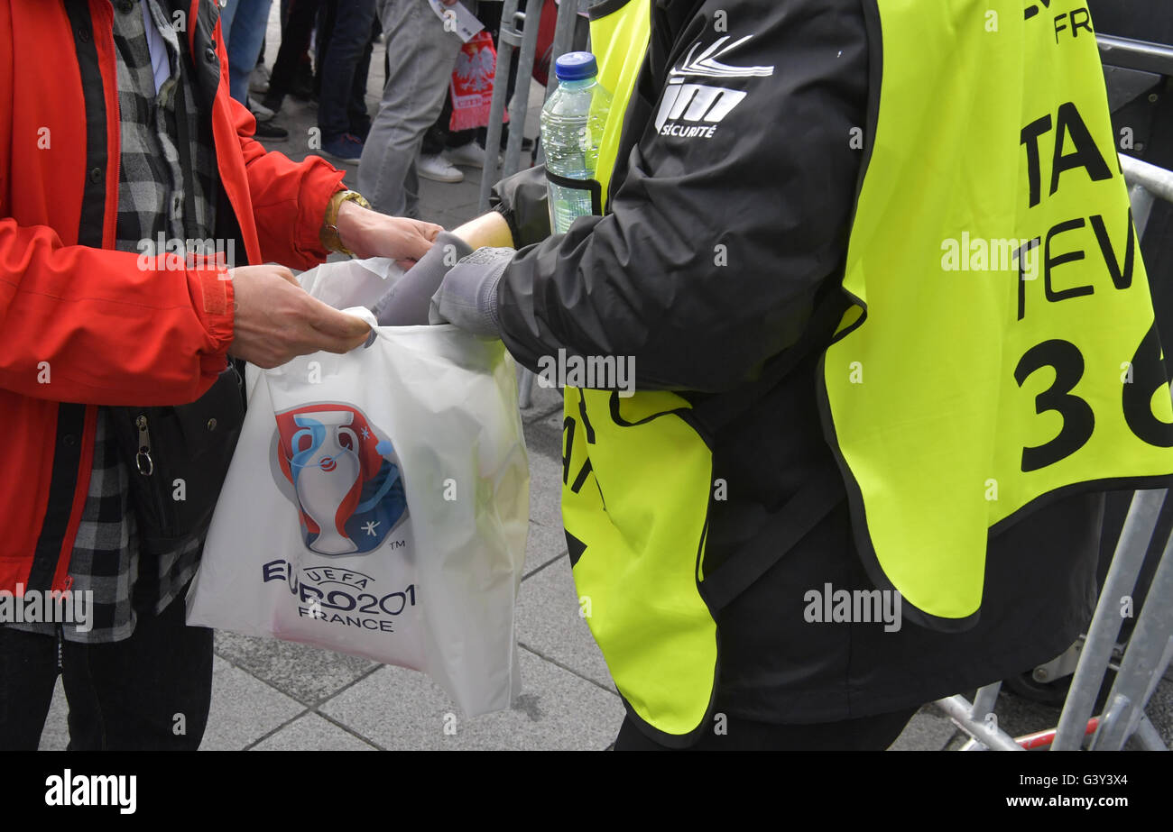 St. Denis, France. 16th June, 2016. The bags of supporters are checked by security personal as they arive at the stadium entrance before the Group C soccer match of the UEFA EURO 2016 between Germany and Poland at the Stade de France in St. Denis, France, 16 June 2016. Photo: Peter Kneffel/dpa/Alamy Live News Stock Photo