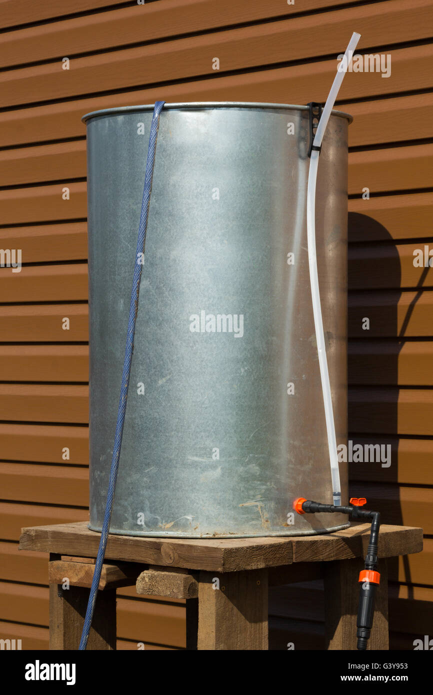 chrome barrel of rainwater with hoses for irrigation Stock Photo Alamy