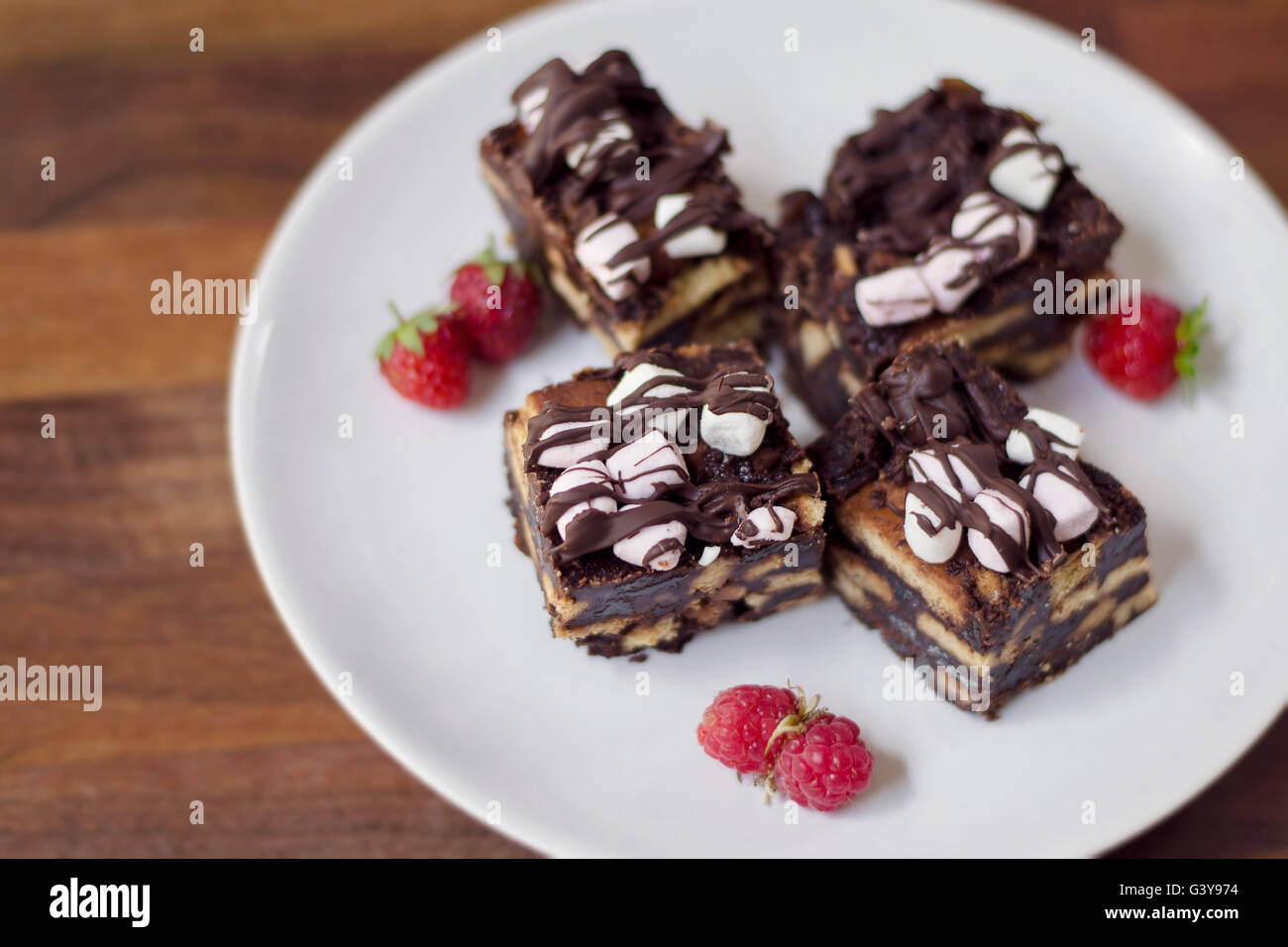 Chocolate biscuit cake with marshmallows and raspberries on a white ...