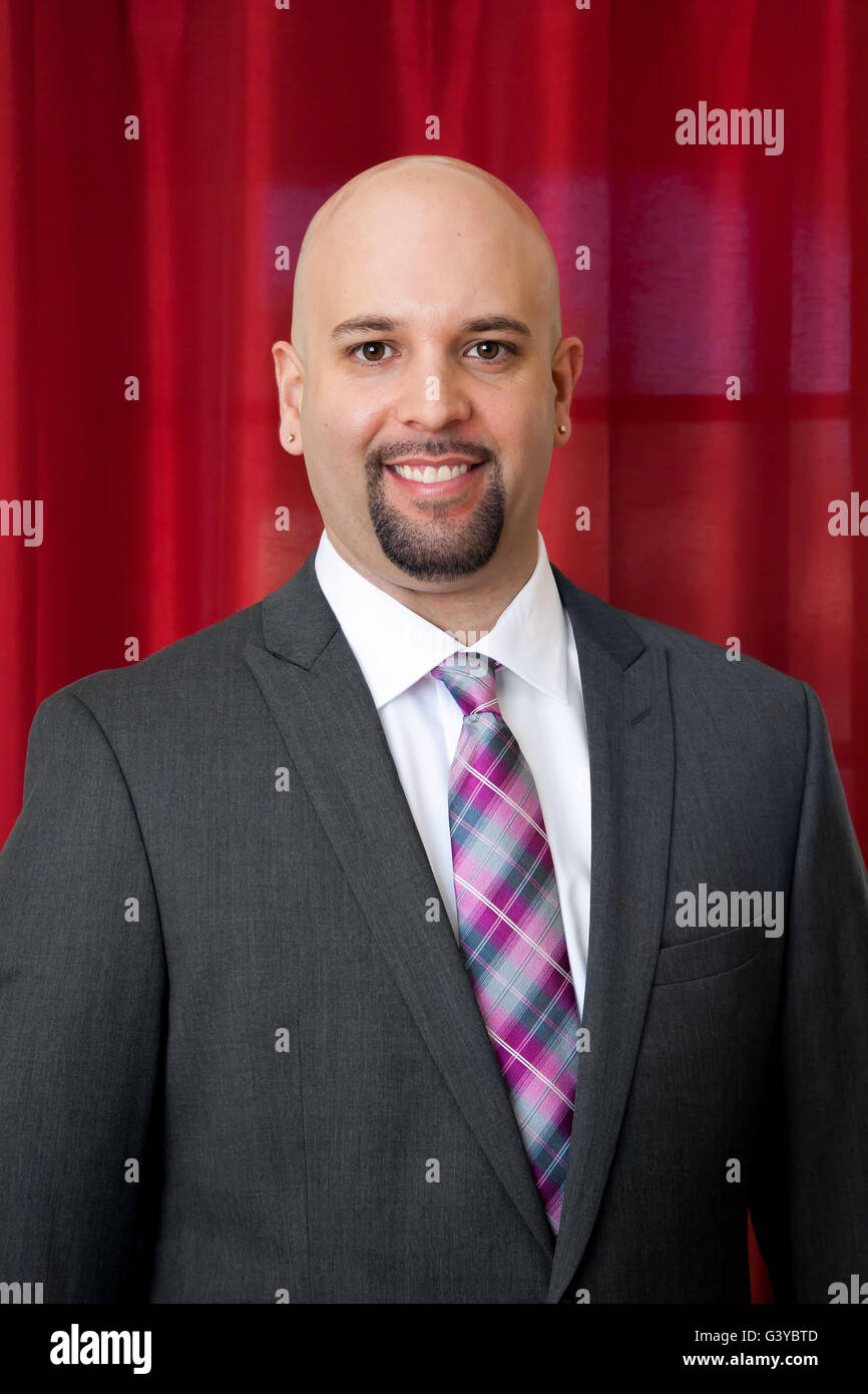 Portrait of a groom in a gray suit and pink and gray tie.  He has a chin beard. Stock Photo