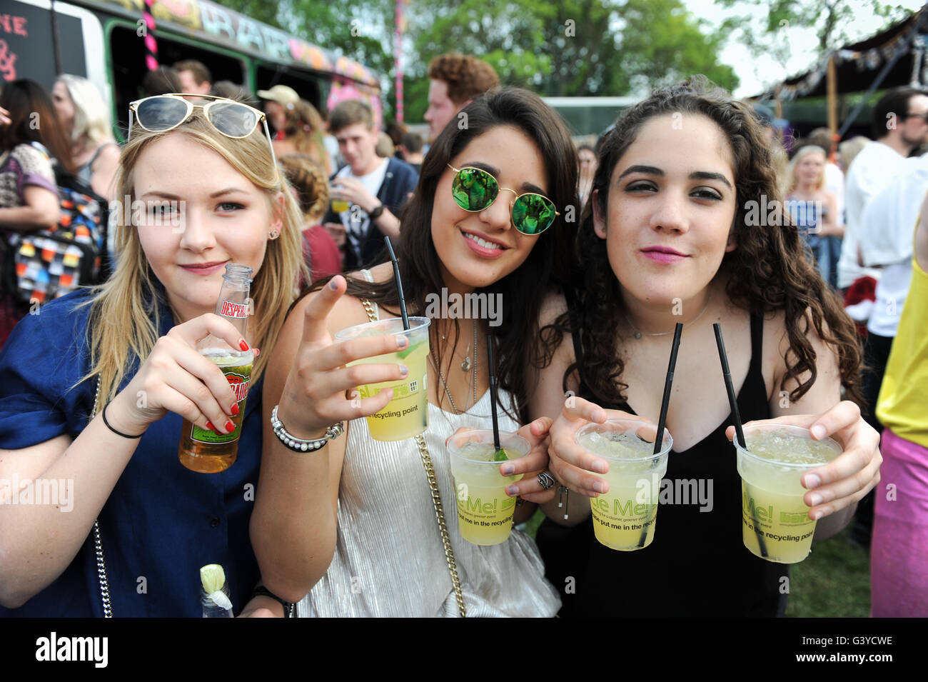 Teenage girls dancing drinking and smoking at music festival Stock Photo
