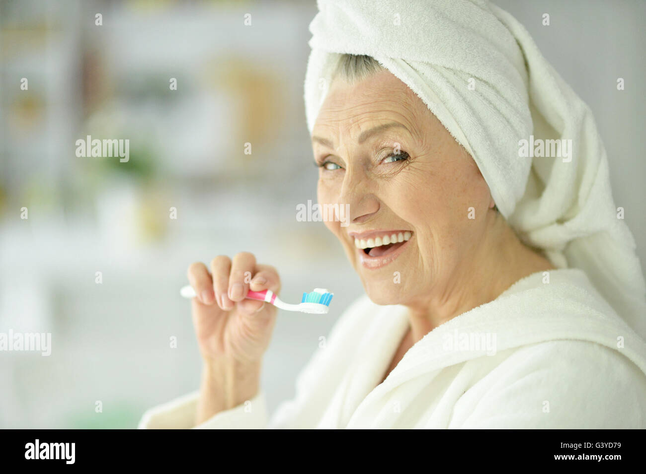 elderly woman brushing her teeth Stock Photo
