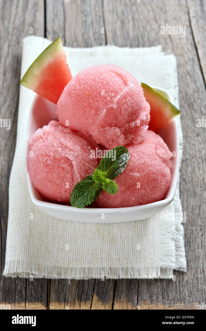 Watermelon sorbet ice cream in bowl on wooden background Stock Photo
