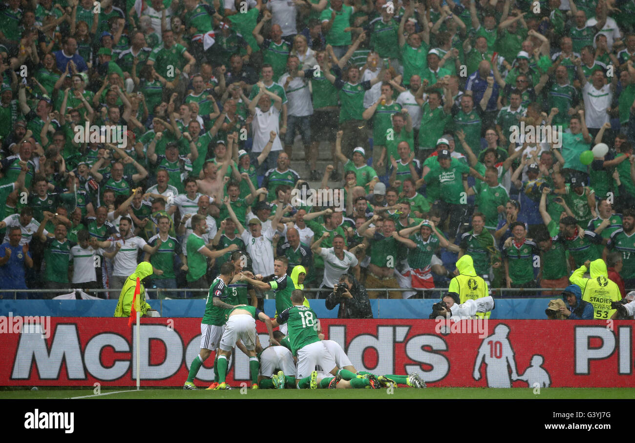 Northern Ireland's Gareth McAuley is mobbed by team-mates after scoring his side's first goal of the game during the UEFA Euro 2016, Group C match at the Parc Olympique Lyonnais, Lyon. Stock Photo