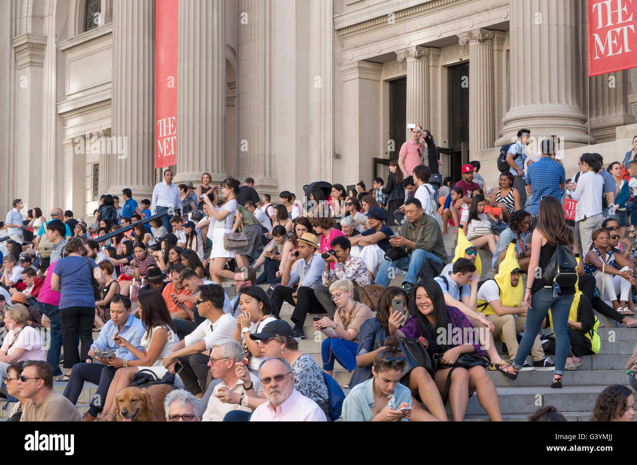 Crowd of people sitting on the steps of the Metropolitan Museum of Art, New York City. Stock Photo