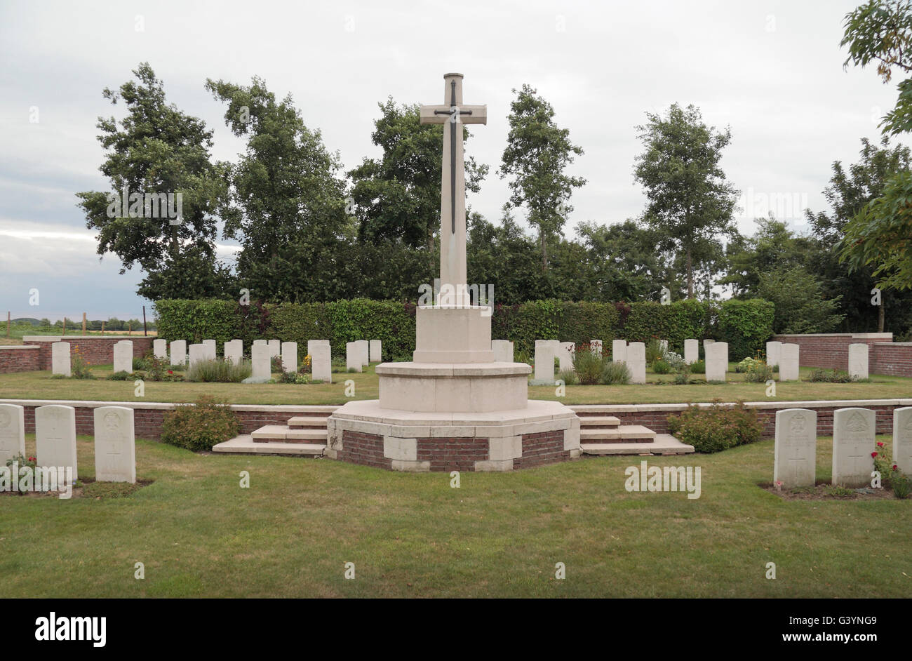 Cross of Sacrifice and headstones in the CWGC Godezonne Farm Cemetery, West-Vlaanderen, Belgium. Stock Photo
