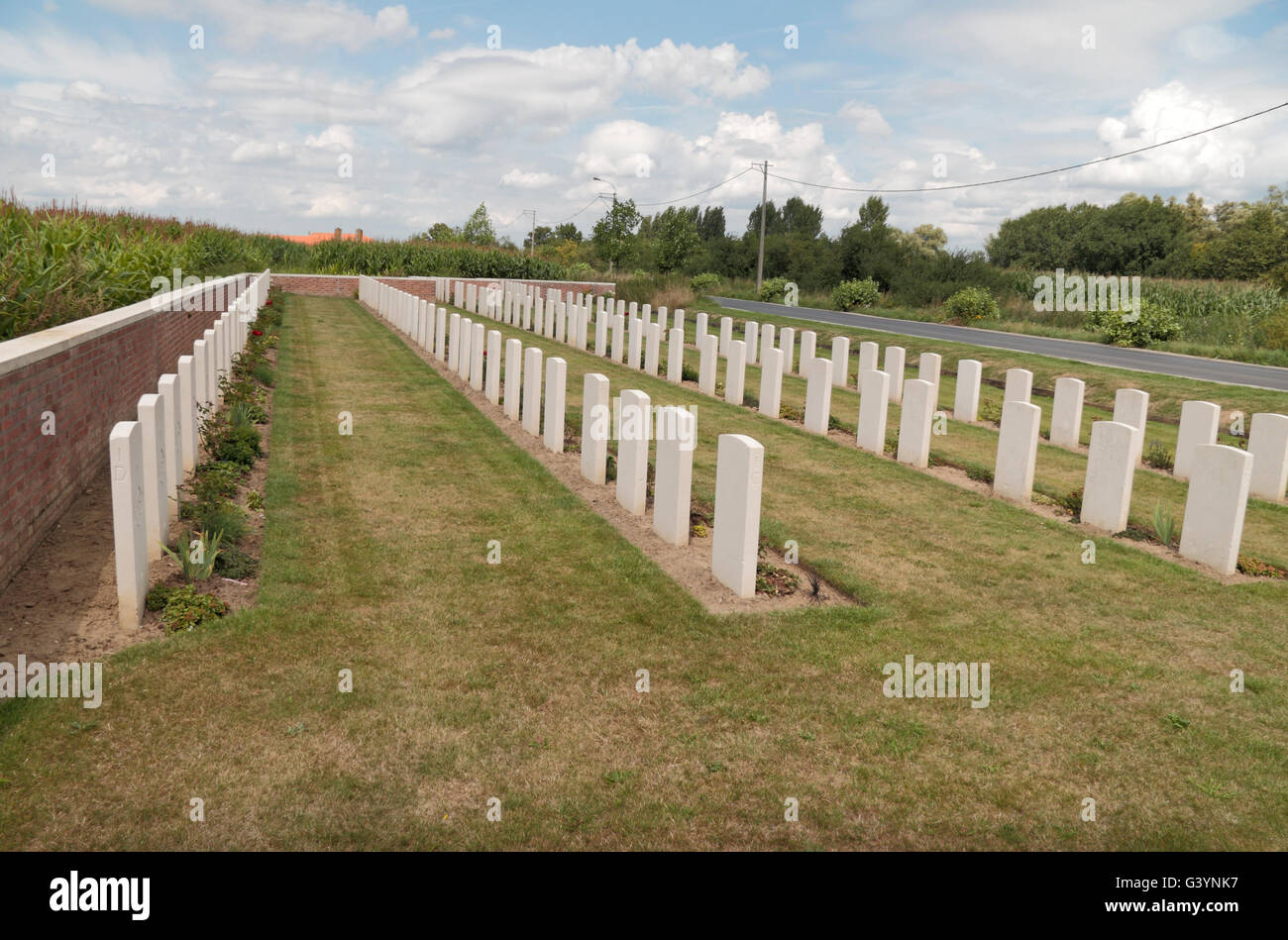 Cross of Sacrifice and headstones in the CWGC Motor Car Corner Cemetery,  Hainaut, Belgium. Stock Photo