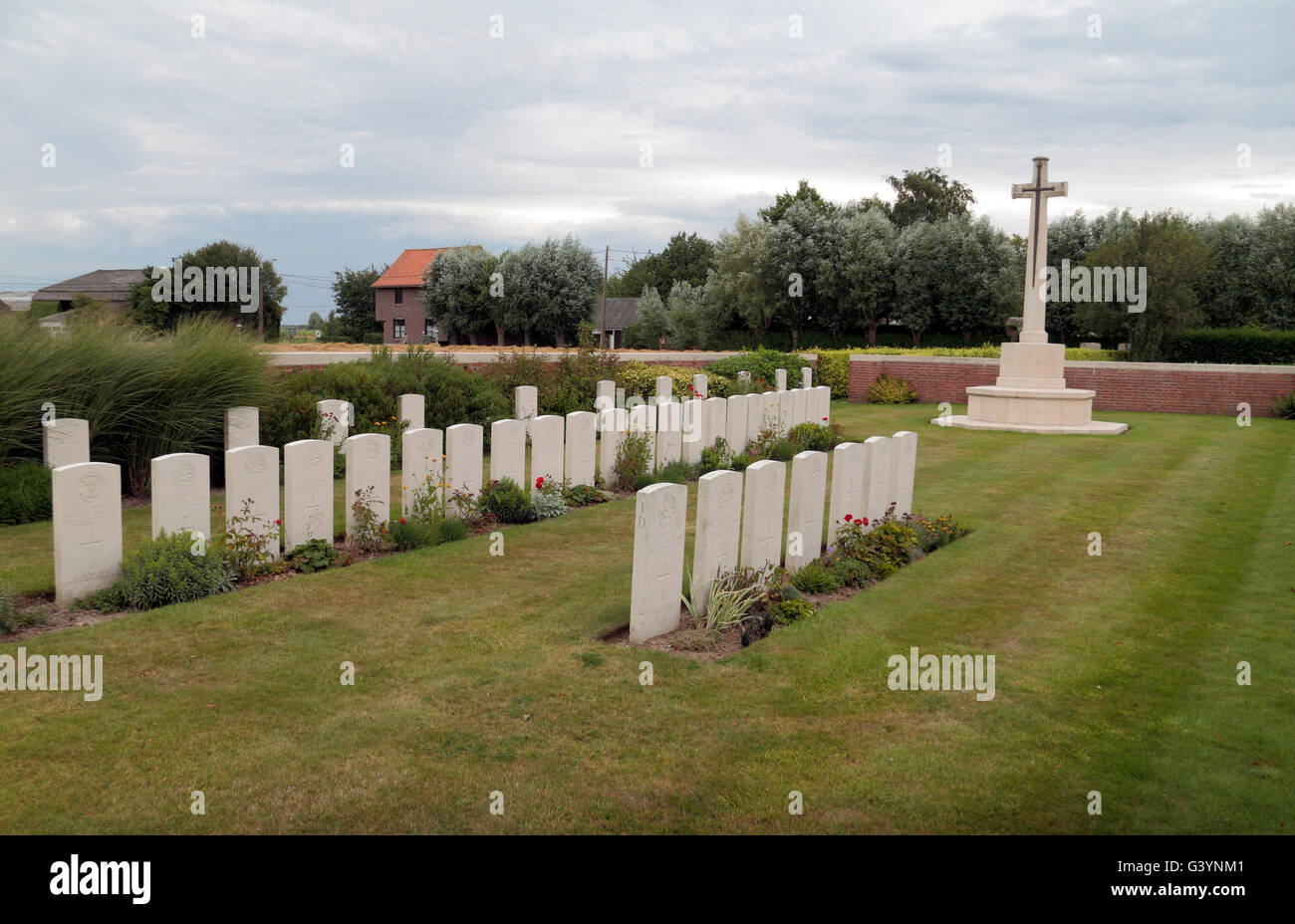 Cross of Sacrifice and headstones in the CWGC Suffolk Cemetery, West-Vlaanderen, Belgium. Stock Photo