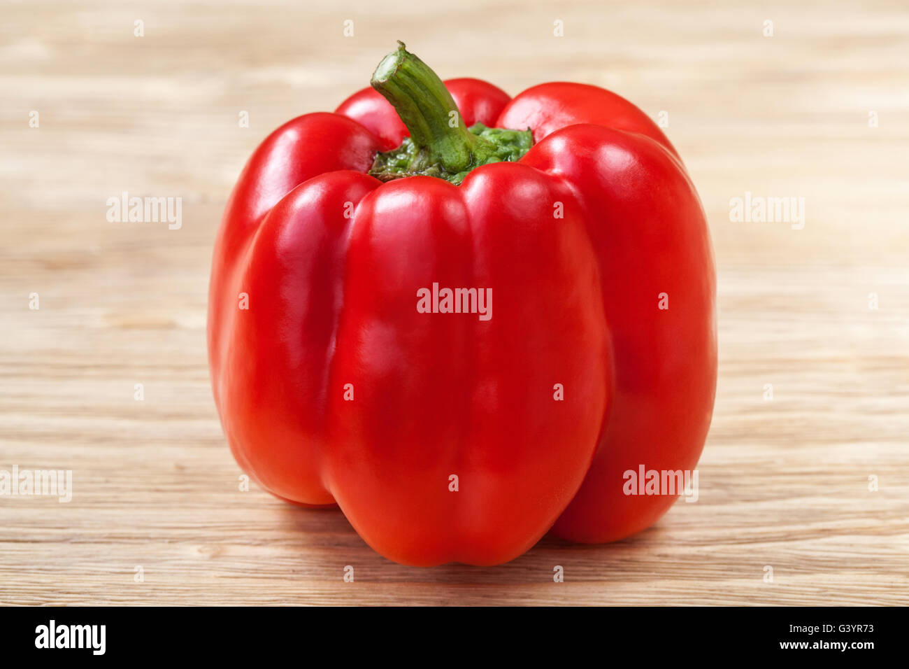 One red sweet bell pepper on a wooden background Stock Photo - Alamy
