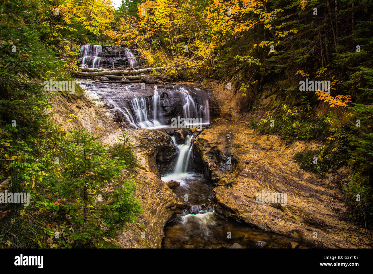 Autumn Waterfall. Sable Falls surrounded by fall foliage in the Pictured Rocks National Lake shore in Michigan. Stock Photo