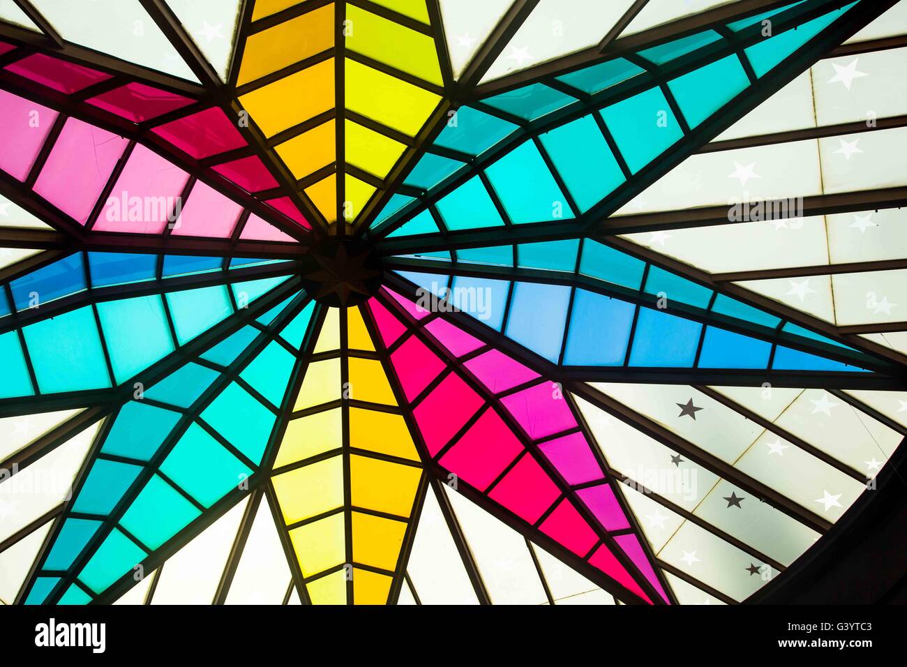 a star shaped colourful roof light or window with blue, pink, green and yellow glass Stock Photo