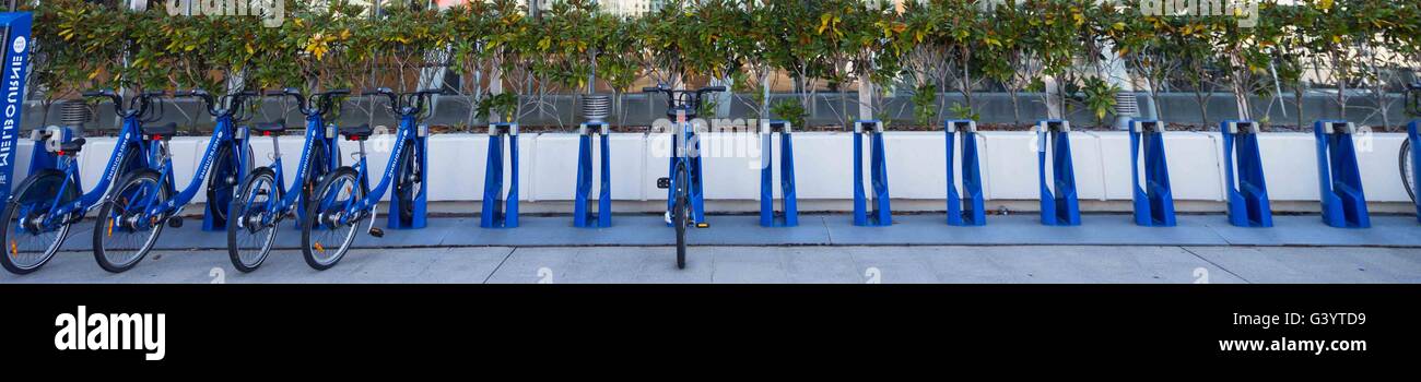 A row of blue cycles or bikes lined up and secured in the City of Melbourne, Australia Stock Photo
