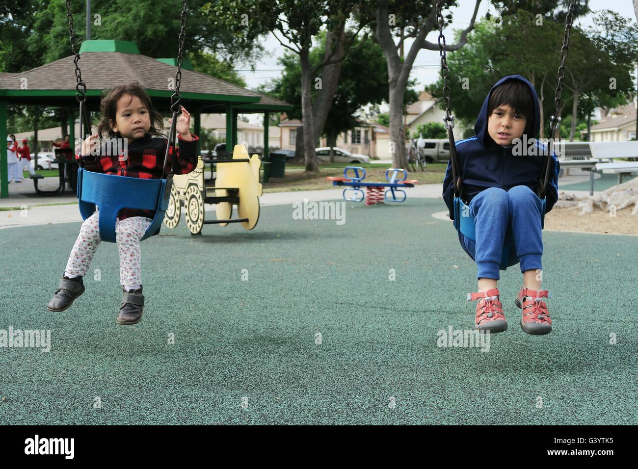 Brother and sister playing together with the swing Stock Photo - Alamy