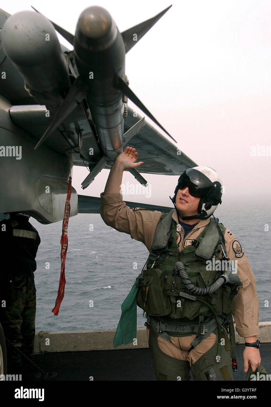 A fighter pilot inspects a Captive Air Training Missile under the wing of an F-14B Tomcat. Stock Photo