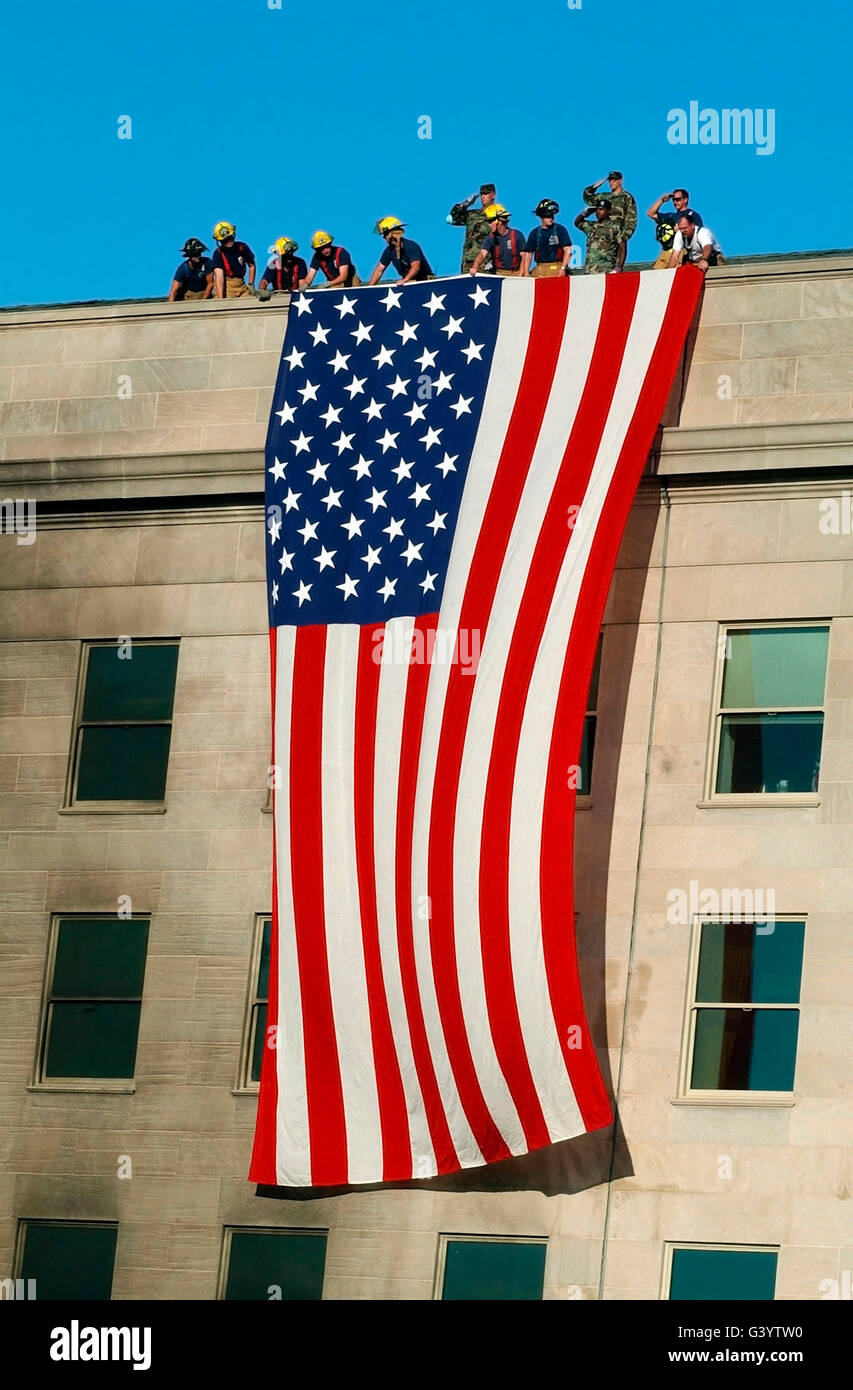 Fire and rescue workers unfurl a huge American flag over the side of the Pentagon. Stock Photo