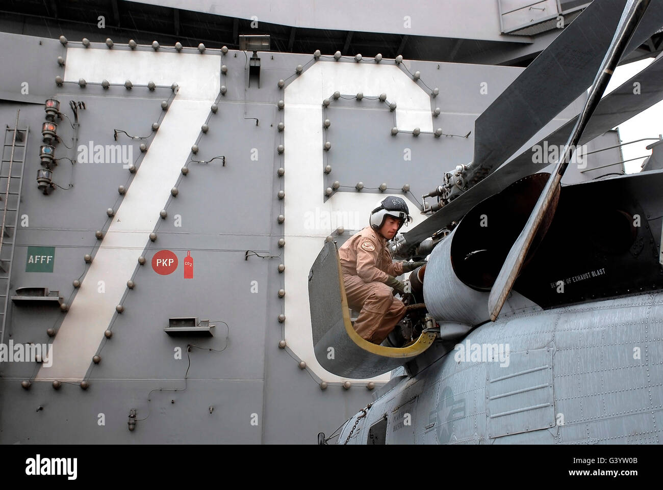 Sailor performs a pre-flight inspection of an SH-60 Seahawk. Stock Photo