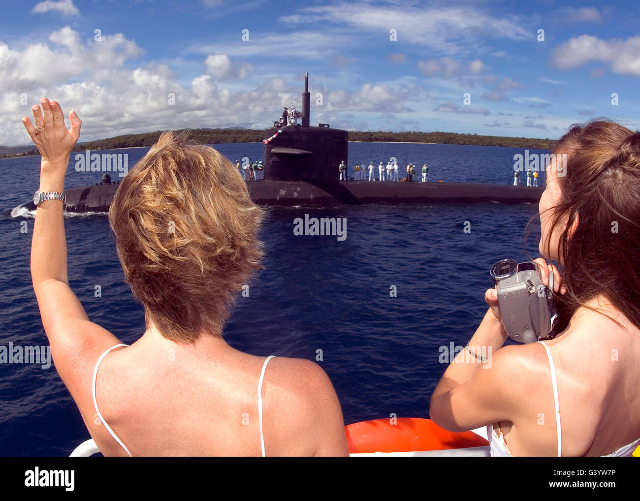 Two spouses wave to their husbands aboard the fast attack submarine USS City of Corpus Christi Stock Photo