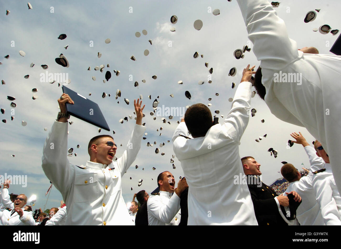 Newly commissioned U.S. Naval Officers celebrate by throwing their hats in the air. Stock Photo